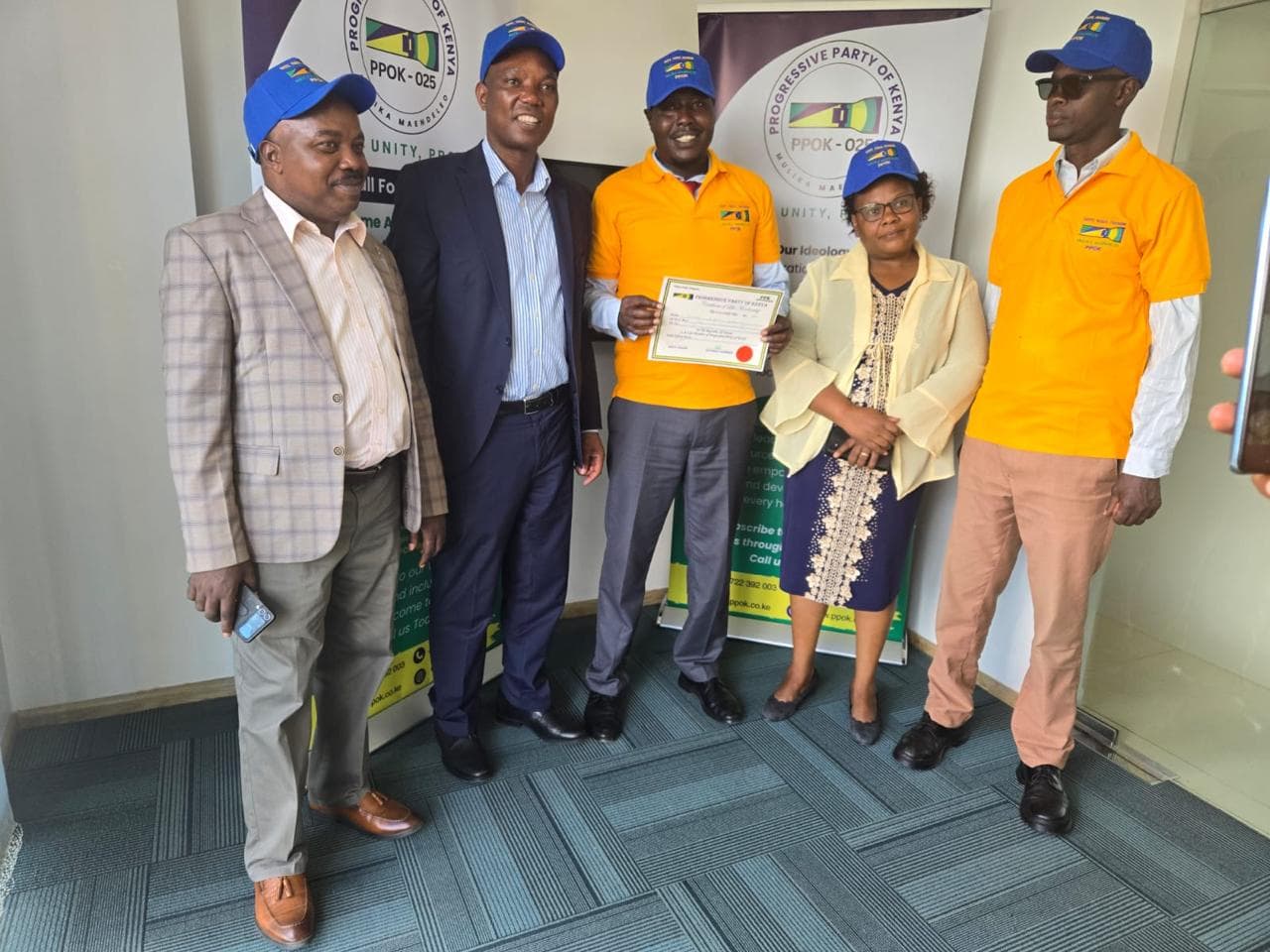 Party officials present a membership certificate to a new member